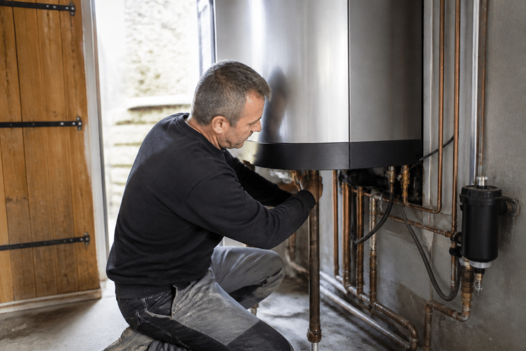 Technicien installant chaudière condensation moderne acier inoxydable