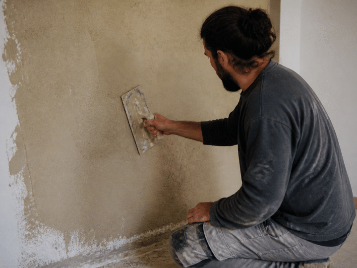 Applicateur étale enduit chanvre beige sur mur intérieur