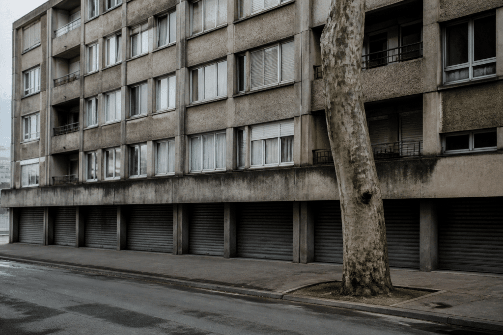 Immeubles résidentiels gris avec commerces fermés visibles