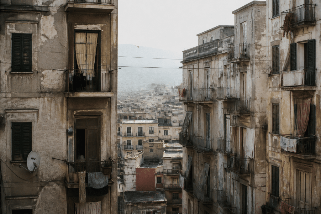 Immeubles urbains denses avec facades usees et tensions visibles