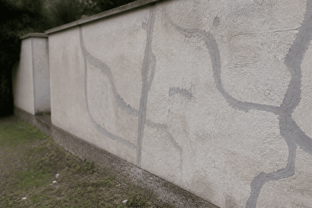 Mur exterieur avec fissures rebouchees au mortier gris