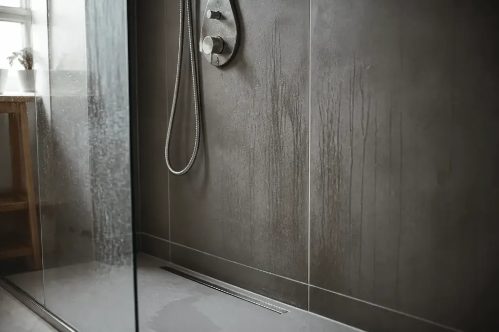Panneaux humides dans douche italienne avec ruissellements d'eau visibles
