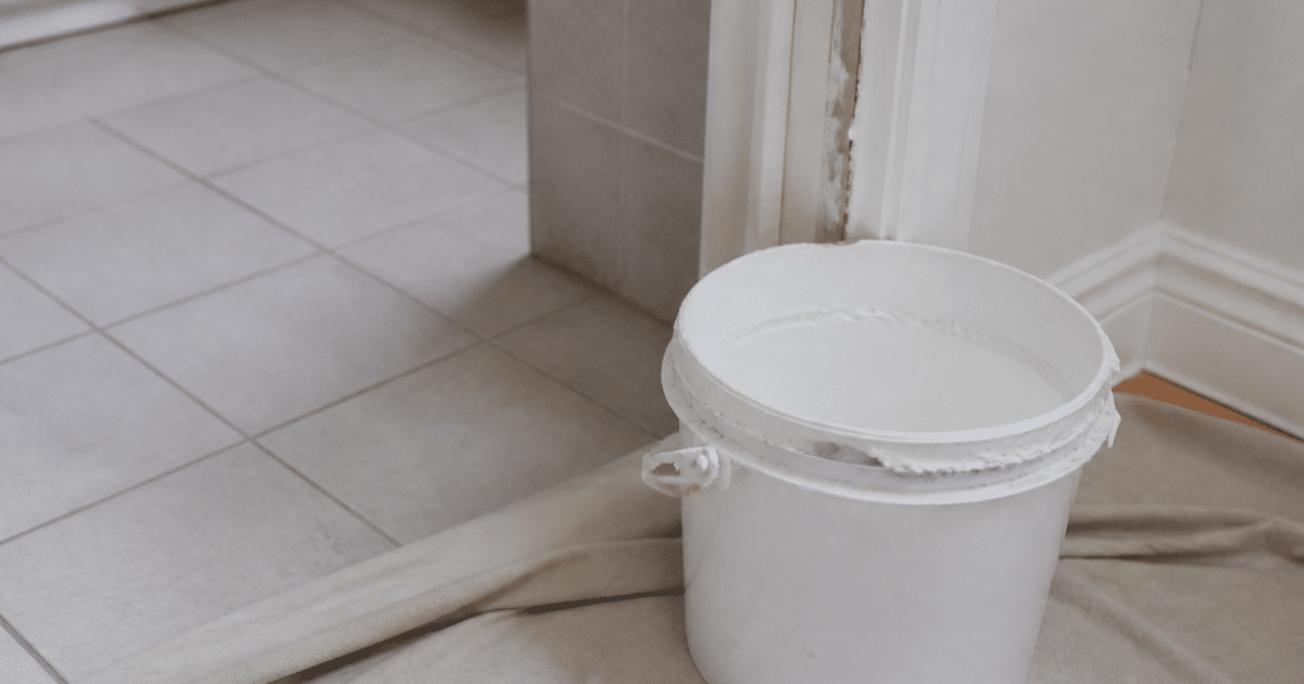Pot de peinture blanche ouvert pres de carrelage salle bain