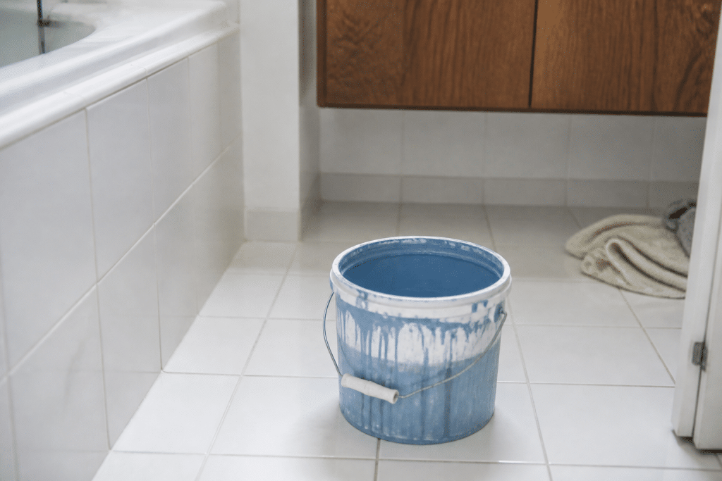 Carrelage blanc salle de bain avec pot peinture bleu