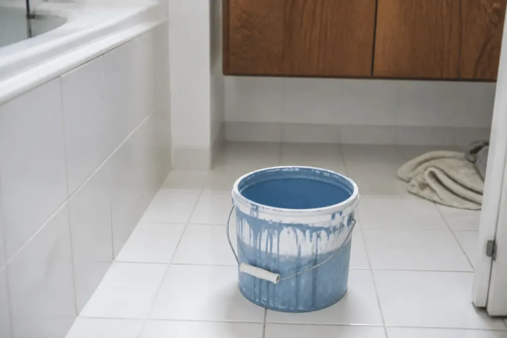 Carrelage blanc salle de bain avec pot peinture bleu