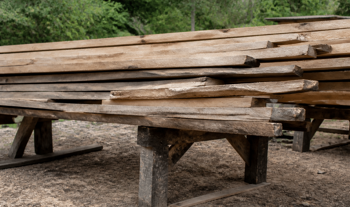 Planches bois empilees horizontalement sur structure support elevee