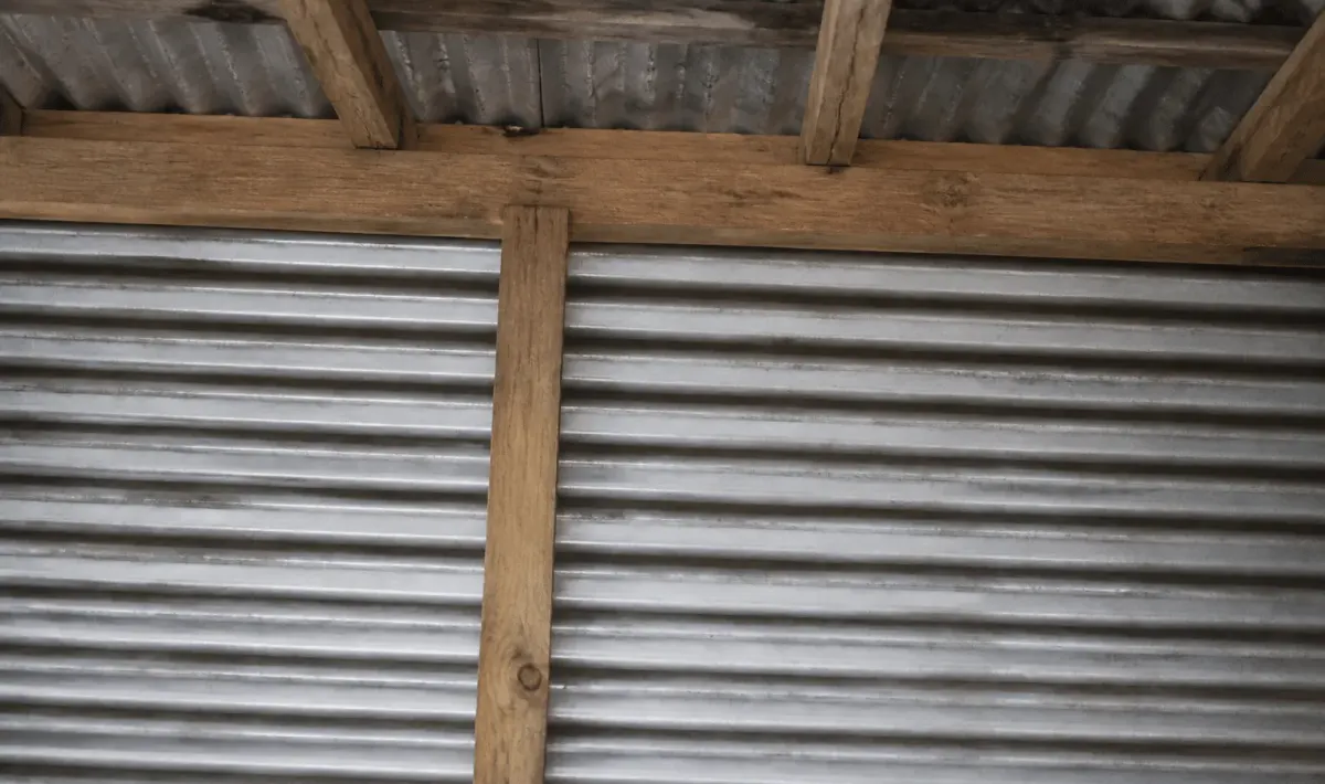 Feuille acier ondulée fixee horizontalement sur charpente bois