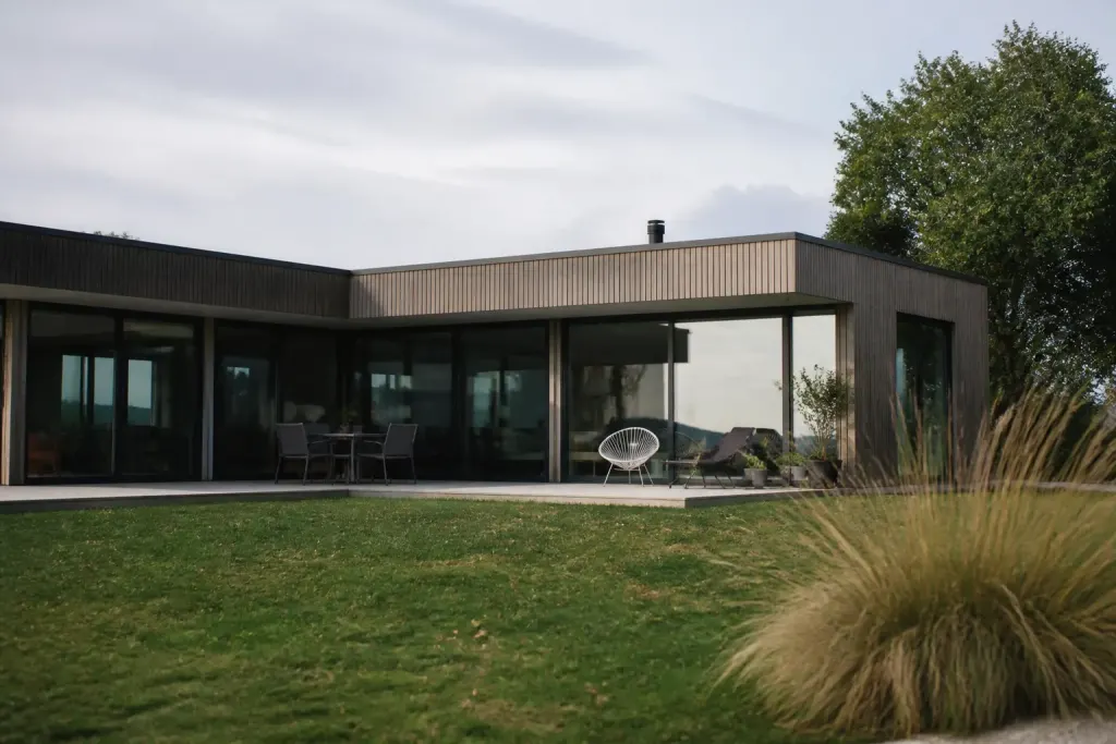 Batiment bois baies vitrees larges toit plat terrasse