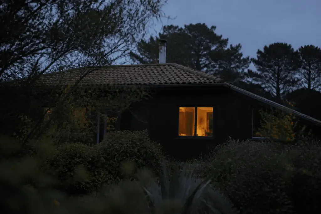Maison sombre la nuit avec fenetre eclairee